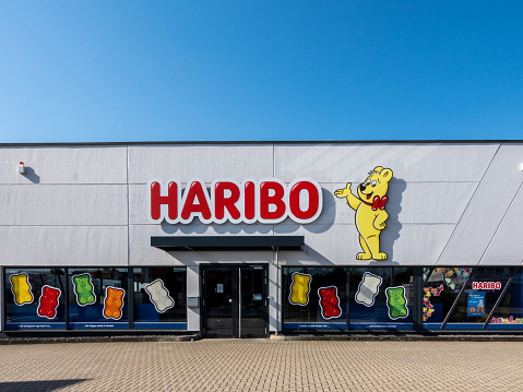 Mulheim-Karlich, Germany - May 18, 2023:: entrance and facade of the Haribo Outlet Store with the famous yellow Haribo bear. Haribo is a German confectionery company