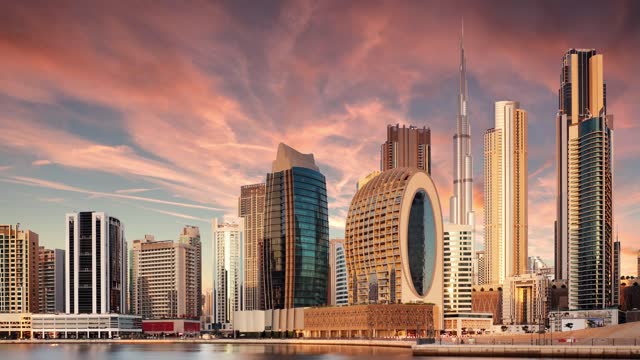 Time lapse of  Dubai skyline with Burj khalifa and other skyscrapers at sunset from Al Jadaf Waterfront; UAE
