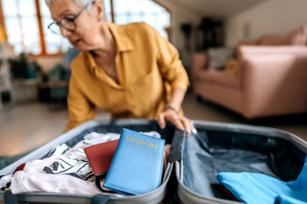 istock Senior woman packing suitcase for vacation 1492833054