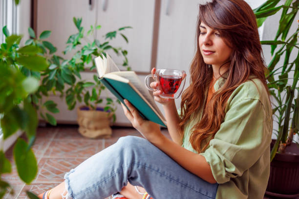 istock Woman reading a book and drinking tea 1492833451