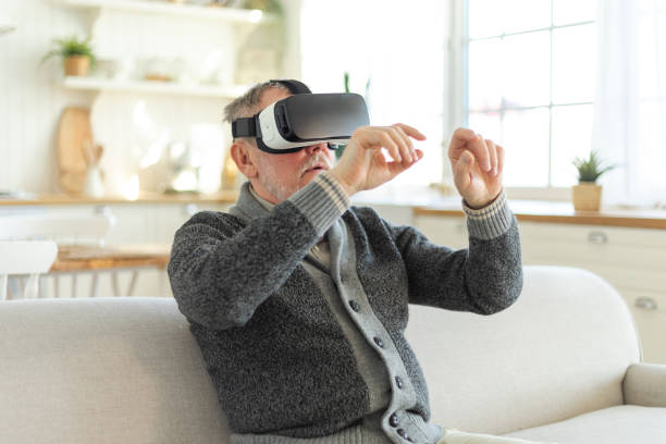 istock Excited mature senior man wearing using virtual reality metaverse VR glasses headset at home. Grandfather touching air during VR experience on virtual reality helmet. Simulation hi-tech videogame. 1492834781