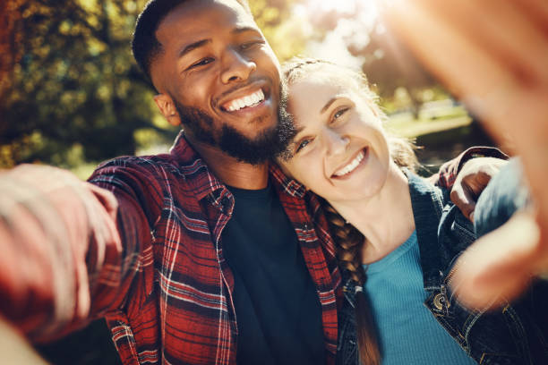 istock Diversity couple, love selfie and portrait outdoors, having fun and bonding together in nature. Comic smile, interracial romance and black man and woman take pictures for happy memory or social media 1492836607