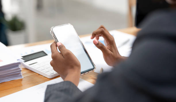istock Closeup image woman hand using mobile phone, sitting at desk office. 1492836905