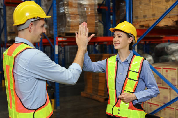 istock Happy smiling teamwork with hardhats and reflective jackets give high five celebrate successful together completed deal commitment at retail warehouse logistics, distribution center, success concept 1492837063