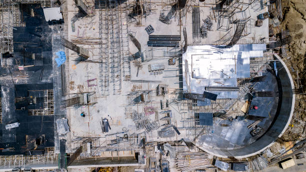 drohnen-luftbild einer aktiven industriebaustelle - construction equipment large construction crane stock-fotos und bilder