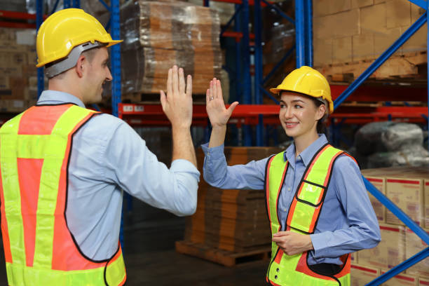 istock Happy smiling teamwork with hardhats and reflective jackets give high five celebrate successful together completed deal commitment at retail warehouse logistics, distribution center, success concept 1492837566