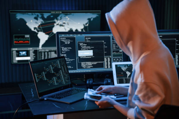 istock With currency in hands. Young professional female hacker is indoors by computer with lot of information on displays 1492837585