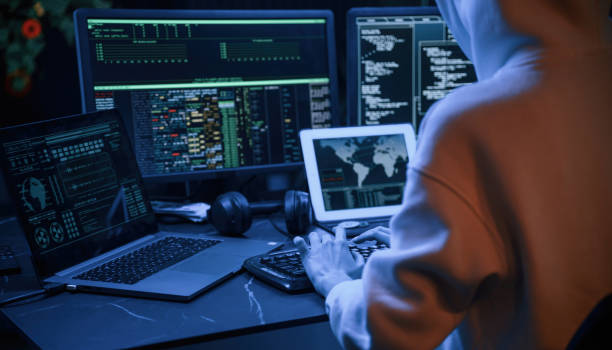 istock Blue neon light. Young professional female hacker is indoors by computer with lot of information on displays 1492838273