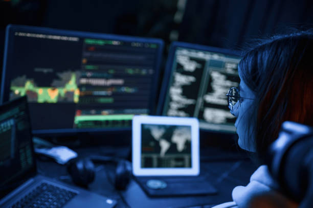 istock Phishing attack. Young professional female hacker is indoors by computer with lot of information on displays 1492838301