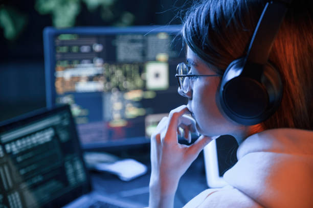 istock Focused on work. Young professional female hacker is indoors by computer with lot of information on displays 1492838394
