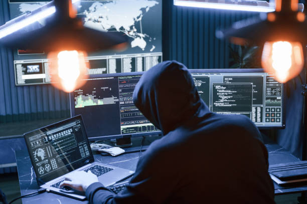 istock Rear view. Male professional hacker is sitting by computer, conception of virus 1492839116