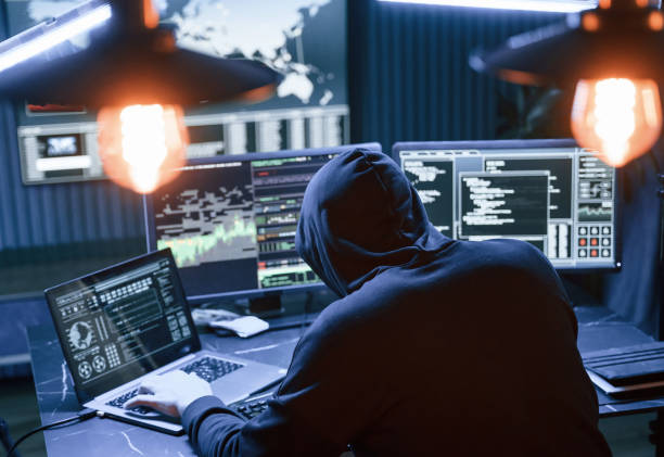 istock Rear view. Male professional hacker is sitting by computer, conception of virus 1492839144