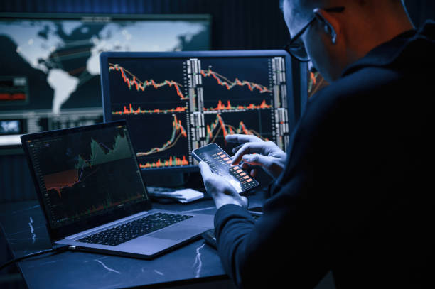 istock With smartphone in hands. Male professional hacker is sitting by computer, conception of virus 1492839192
