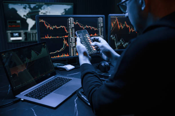 istock With smartphone in hands. Male professional hacker is sitting by computer, conception of virus 1492839209