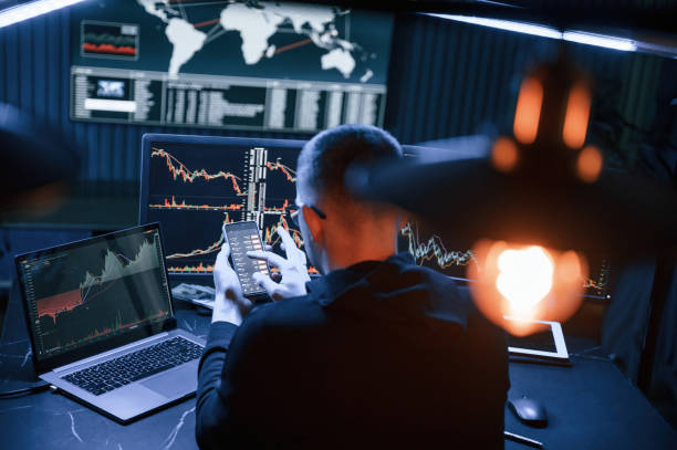 istock With smartphone in hands. Male professional hacker is sitting by computer, conception of virus 1492839211