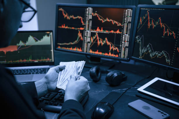 istock Holding currency in hands. Male professional hacker is sitting by computer, conception of virus 1492839300