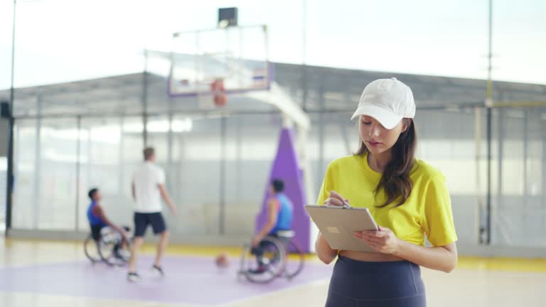 Attractive female  coach Wheelchair Basketball  in gym.