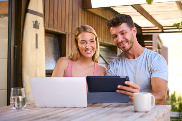 istock Couple With Laptop And Digital Tablet Outdoors On Table At Home 1492846100