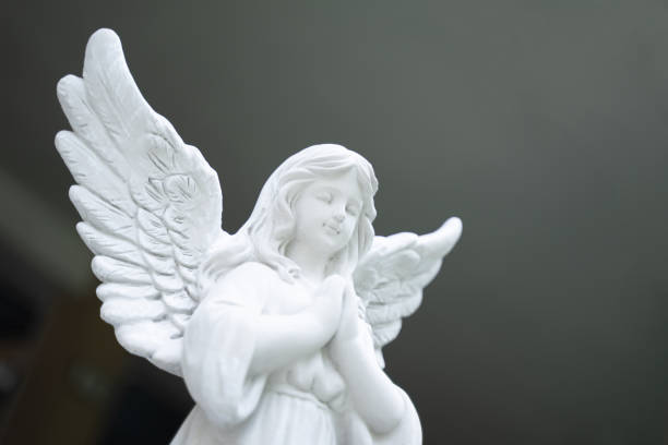 istock Cupid stucco doll, white girl, clasped hands, blurred light background 1492846369