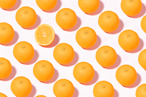 Orange fruit pattern with half slices of orange  on pink background