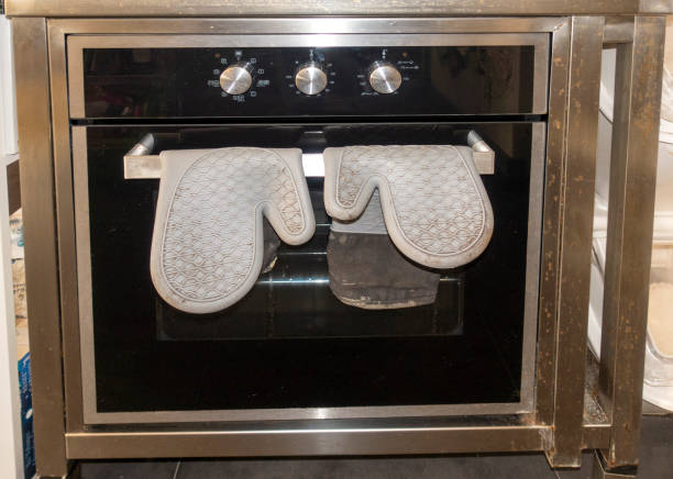 Oven and oven gloves in kitchen