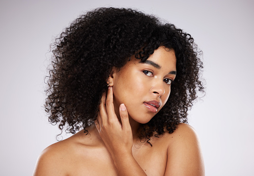 istock Skincare, looking and portrait of a black woman feeling face isolated on a grey studio background. Beauty, African and model touching skin to check for acne, grooming and routine on a backdrop 1492856350