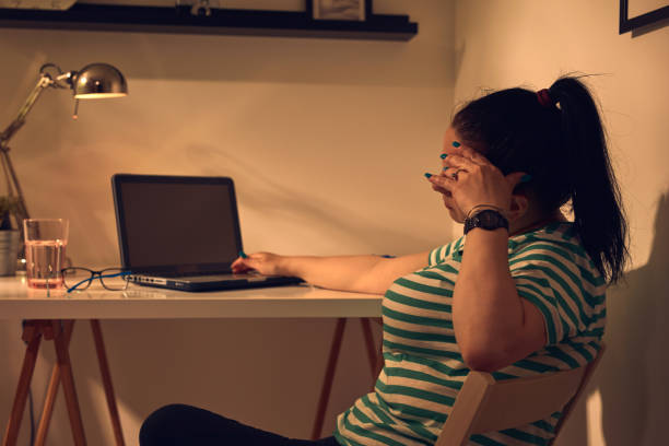 istock Woman with headache and feeling exhausted while working on a laptop at home. 1492858519