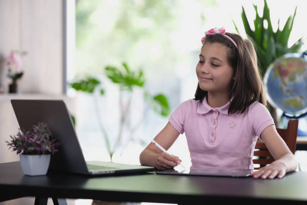 istock Child girl using digital tablet and laptop computer at home. Concept for daily use of technologies for children. 1492859437
