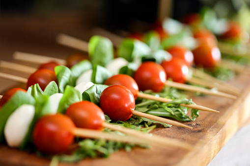 Cherry tomato and mozzarella on skewers on a buffet table.