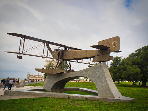 Lisbon, Lisbon, Portugal - July 06 2019 : A model of the 'Santa Cruz' biplane on display next to the Belem Tower with both monuments admired by onlookers.
