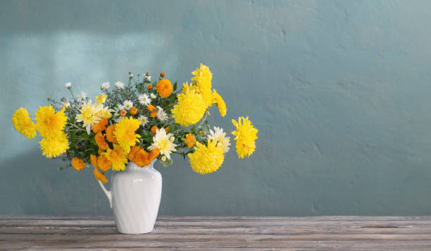 istock yellow and white chrysanthemum in white jug on wooden table 1492865804
