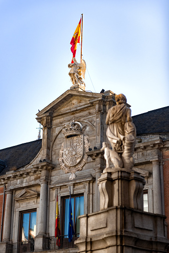 The Spanish flag is depicted flying on the top of a clock tower in a government building in Madrid