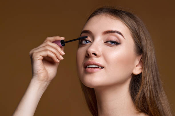 istock young woman applying black mascara on long thick eyelashes 1492869738
