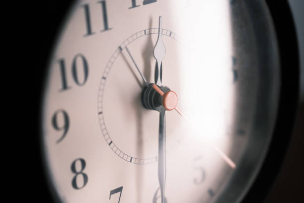 primer plano de un reloj antiguo aislado sobre fondo oscuro - clock time alarm clock urgency fotografías e imágenes de stock