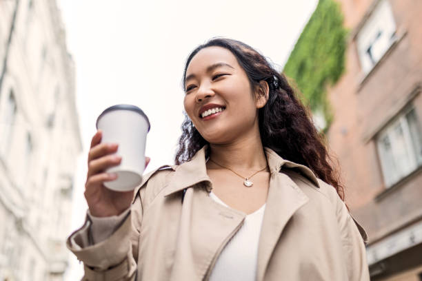 istock Smiling young asian businesswoman drinking coffee 1492872429