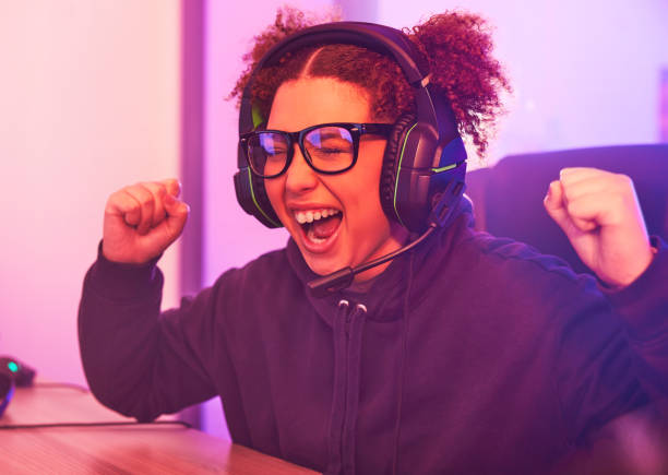 istock Winner, streamer or woman gamer success on computer with microphone celebrating game win or fist bump. Happy or esport girl player celebration for online competition, gaming progress or achievement 1492873496