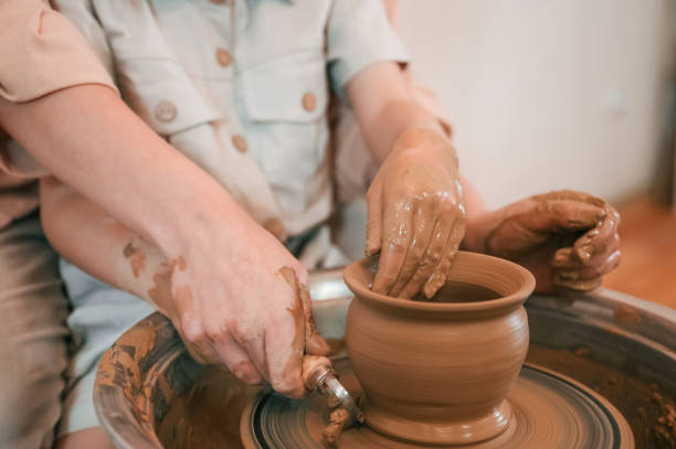 istock Using clay to create the pot. Mother with little girl learning pottery in the workshop 1492874130