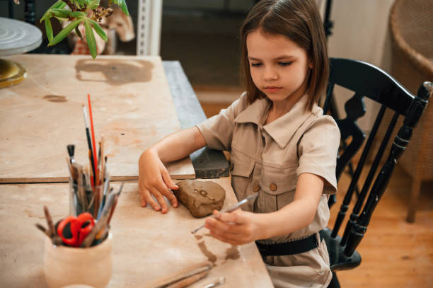 istock Little girl is learning how to do pottery in the workshop 1492874278