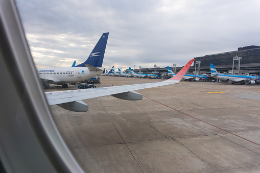 View to an airport terminal at Schiphol Airport and luggage charts under the wing of a Boeing 787