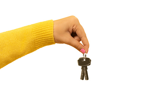female hand holding house keys, suggesting, isolated on white background
