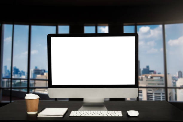 istock Computer monitor with white blank screen putting on white working desk with wireless mouse and keyboard over blurred vintage office as background. 1492888439