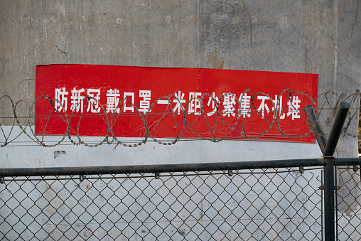 Strict Covid-19 policy has finished in China, people are walking pass the red slogan with or without mask.