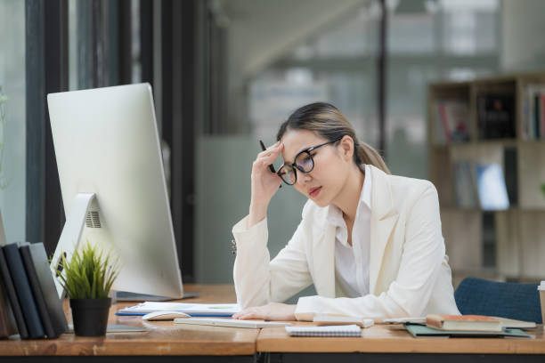 istock An Asian businesswoman working on a desktop computer is stressed has a headache, and thinks hard from work at the office. 1492893147