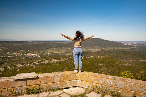 Woman with arms raised contemplating nature viewpoint in Serra da Arrábida in Setúbal, Portugal