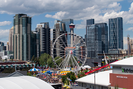 Calgary, AB, Canada-August 2022; High angle view over Stampede Park during the Calgary Stampede, the greatest outdoor show on earth, with rodeo and chuckwagon races and downtown in background