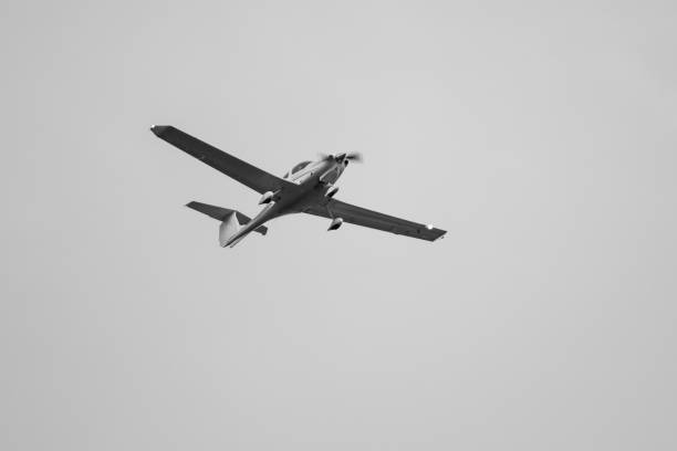 istock Gray one-engine airplane flying in gray sky 1492895428