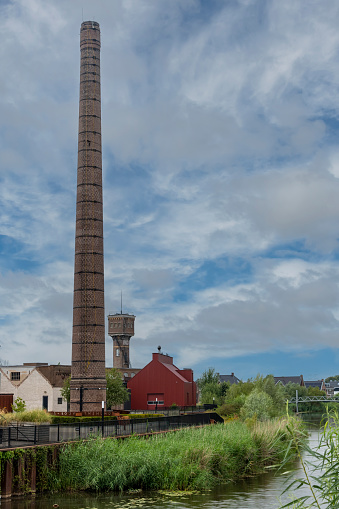 Ulft, the Netherlands-August 2022; View of DRU Culture Factory, a refurbished old iron-casting factory with remaining old architectural details like the high chimney along the Oude IJssel River