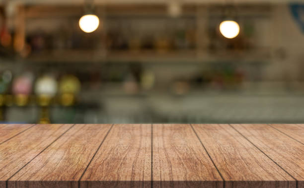 istock Empty wooden table top with lights bokeh on blur restaurant background. 1492898044