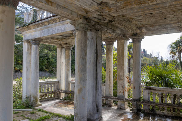 Fragment of decay marble colonnade of abandoned railway platform Gagrypsh overgrown with tropical greenery in Gagra, Abkhazia, Georgia