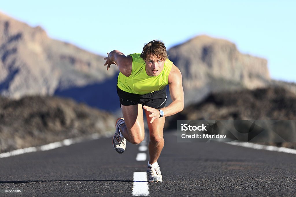 Sprinter running on road Sprinter. Man running on road at high speed in beautiful exotic mountain landscape. Male athlete runner in intense sprint during outdoor workout. Click for more: 20-29 Years Stock Photo